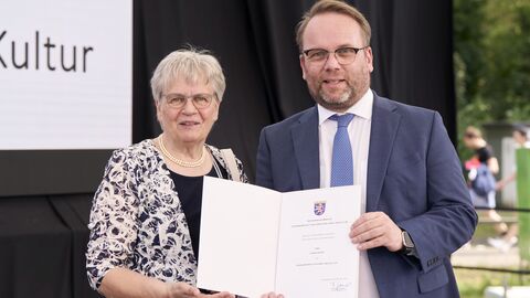 Minister Gremmels übergibt Luzine Happel die Ehrenurkunde für Kunst und Kultur.
