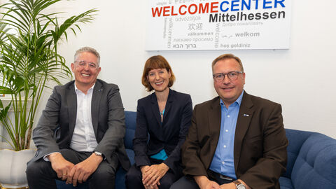Drei Personen (Min Hofmann) in der Mitte auf einer Couch im neuen Welcomecenter Wetzlar